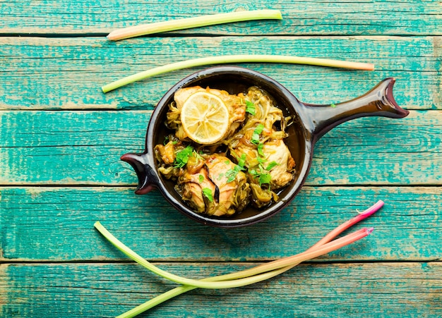 Délicieuse viande de poulet rôtie avec tiges de rhubarbe. Poitrine de poulet sauce rhubarbe sur table en bois