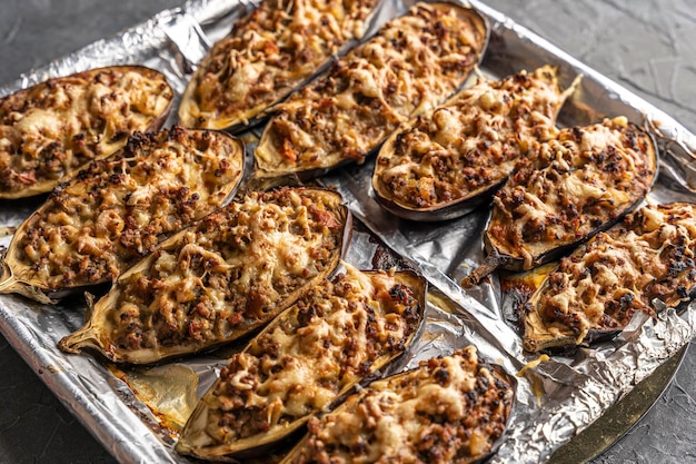 Délicieuses aubergines cuites au four avec de la viande sur une plaque à pâtisserie