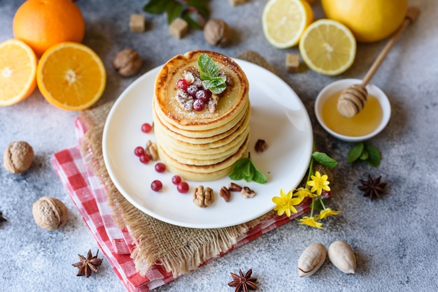 Délicieuses belles crêpes fraîches avec du miel d'agrumes et de la confiture. Délicieux petit déjeuner chaud avec des crêpes aux fruits et baies