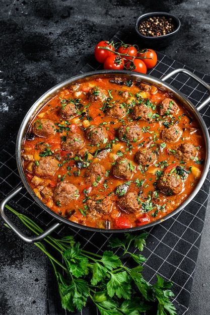 De délicieuses boulettes de viande à base de boeuf haché à la sauce tomate, servies dans une vieille poêle en métal. Vue de dessus