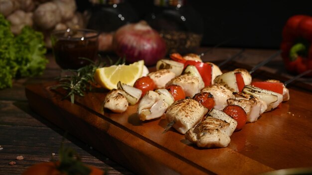 Délicieuses brochettes de barbecue brochettes de poulet aux légumes sur une plaque en bois