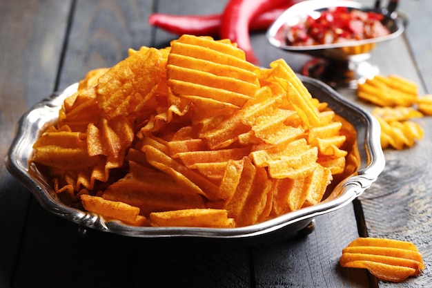 Délicieuses chips de pommes de terre sur une assiette sur une table en bois libre