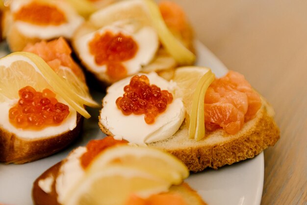 Délicieuses collations italiennes à la tomate épicée ou bruschetta sur des tranches de baguette grillée décorées de jambon de poisson rouge au basilic sur une planche de bois