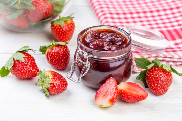 De délicieuses confitures de fraises et de fraises maison sur une table en bois rustique