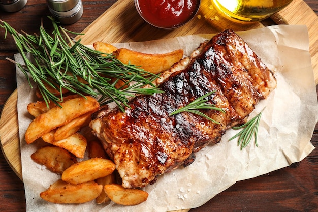 Délicieuses côtes levées grillées et garniture sur une table en bois à plat