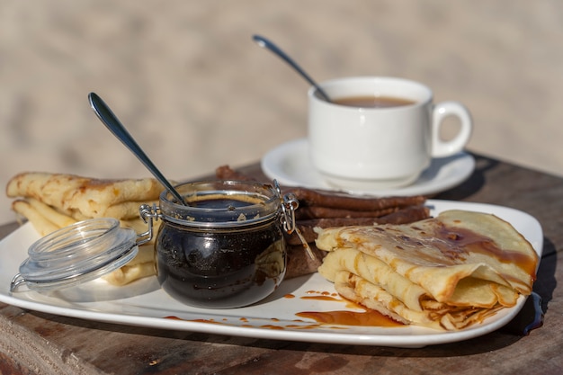 Délicieuses crêpes au miel de mangrove et tasse de thé blanc sur la table, Close up