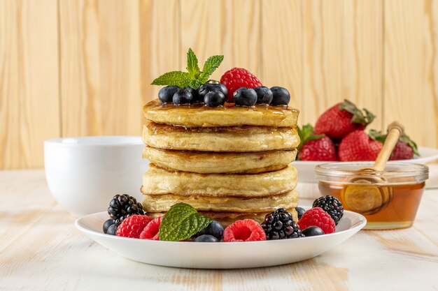 Délicieuses crêpes aux fruits frais sur table en bois blanc