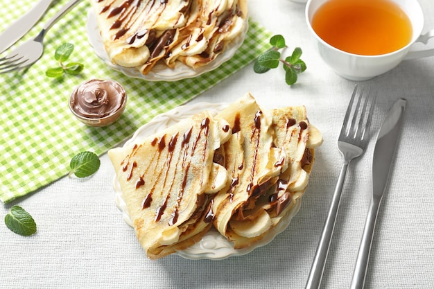 Délicieuses crêpes à la banane et pâte de chocolat sur plaque