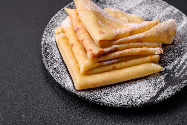 De délicieuses crêpes fraîchement cuites au four avec du miel et des fruits sur un fond de béton