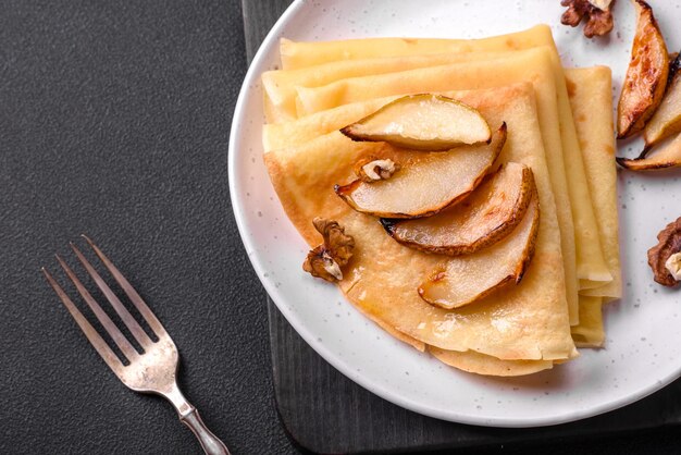 De délicieuses crêpes fraîchement cuites au four avec du miel et des fruits sur un fond de béton