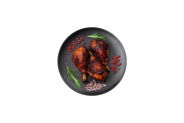 Délicieuses cuisses de poulet grillées aux épices et herbes à la sauce teriyaki sur fond de béton foncé