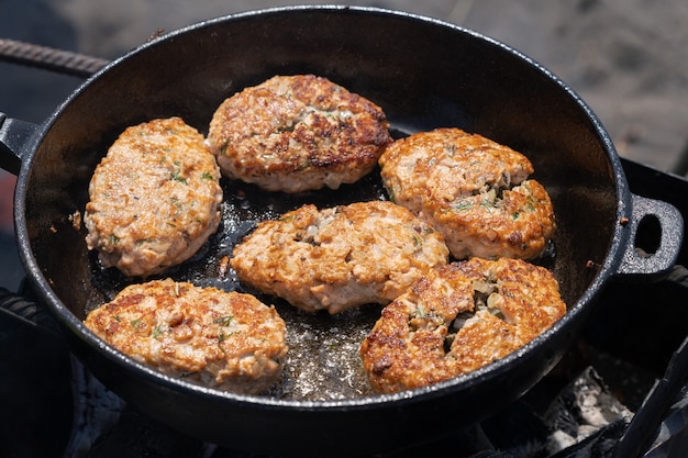 Délicieuses escalopes croustillantes de poisson saumon rouge sauvage frites dans une plaque chauffante chaude rôtie sur des charbons au feu ouvert sur ...