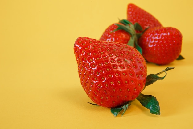 Délicieuses fraises fraîches sur jaune