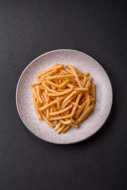 Délicieuses frites dorées croustillantes avec sel et épices