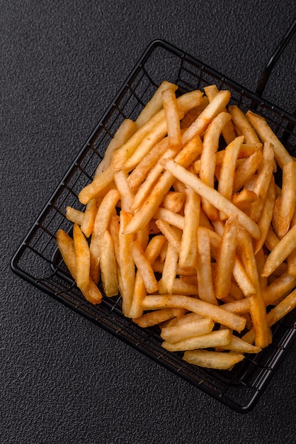 Délicieuses frites dorées croustillantes avec sel et épices