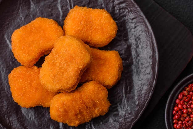 De délicieuses nuggets de poulet croustillants sur un fond de béton sombre