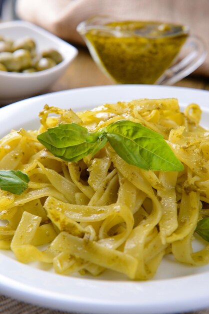 Délicieuses pâtes au pesto sur une assiette sur la table en gros plan