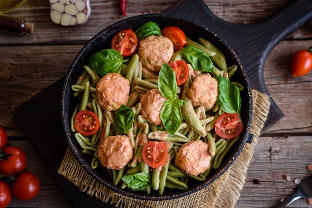 Délicieuses pâtes fraîches avec boulettes de viande, sauce, tomates cerises et basilic