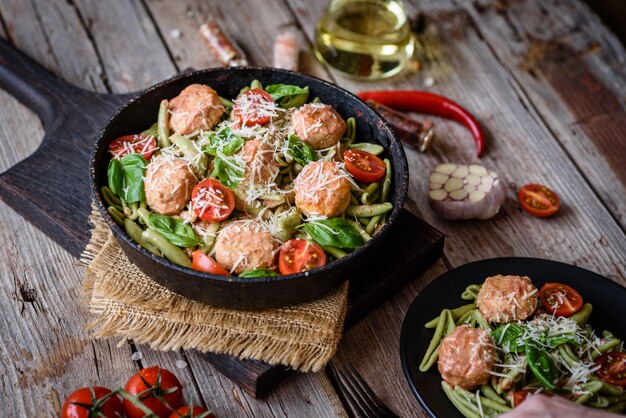 Délicieuses pâtes fraîches avec boulettes de viande, sauce, tomates cerises et basilic