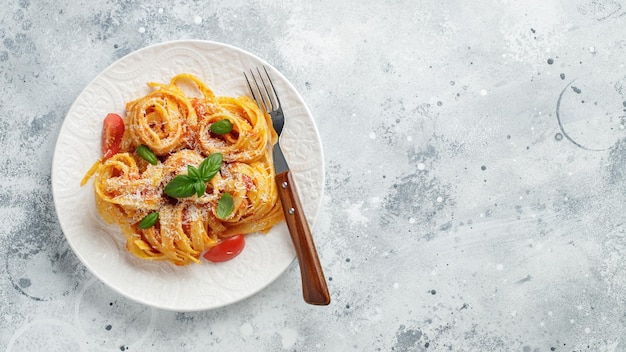 Délicieuses pâtes italiennes classiques appétissantes avec sauce tomate, parmesan et basilic sur fond...