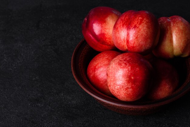 Photo délicieuses pêches douces ou nectarines dans un bol brun