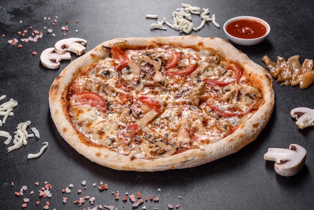 De délicieuses pizzas italiennes fraîches aux champignons et tomates sur fond de béton foncé. cuisine italienne