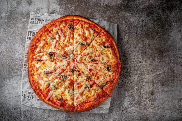 De délicieuses pizzas italiennes fraîches sur un fond de table en pierre grise