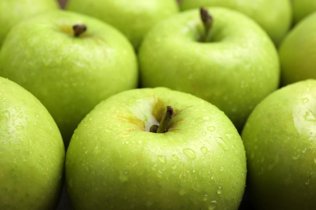 Délicieuses pommes vertes mûres avec des gouttes d'eau comme gros plan d'arrière-plan