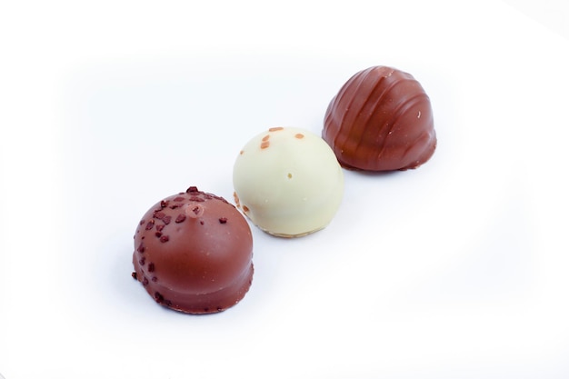 De délicieuses pralines au chocolat noir, au lait et blanc.