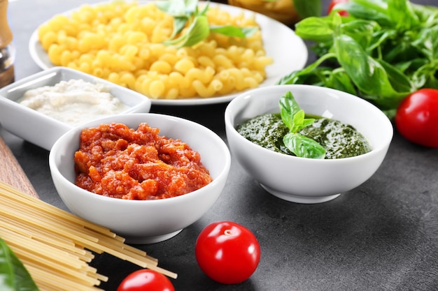 De délicieuses sauces bolognaises au pesto et blanches pour les pâtes dans des bols sur la table