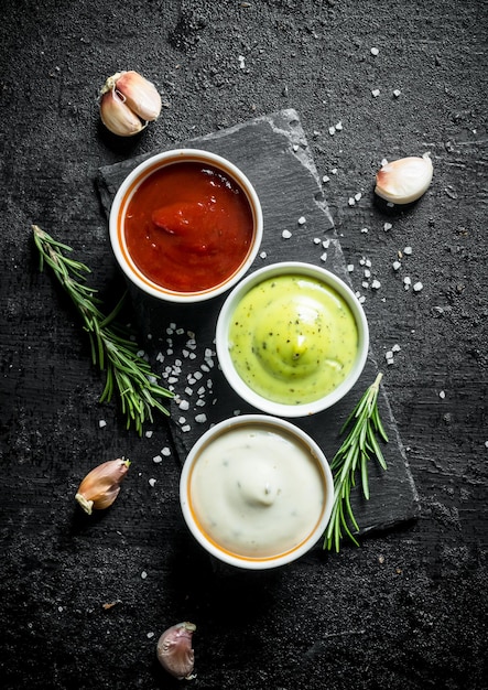 Photo délicieuses sauces guacomole mayonnaise et ketchup aux gousses d'ail et romarin