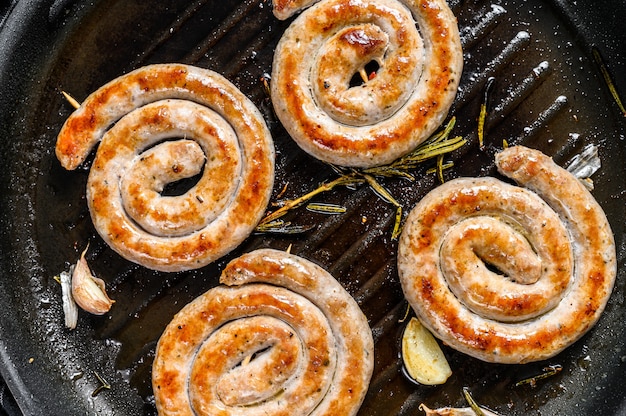 Délicieuses saucisses grillées en spirale avec des légumes dans la casserole