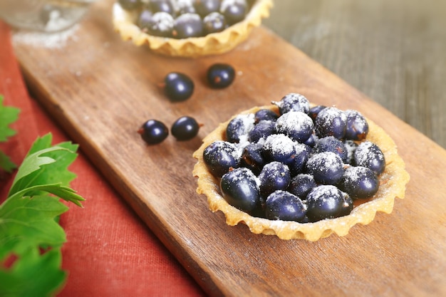 Délicieuses tartes croustillantes aux cassis sur planche à découper en bois libre