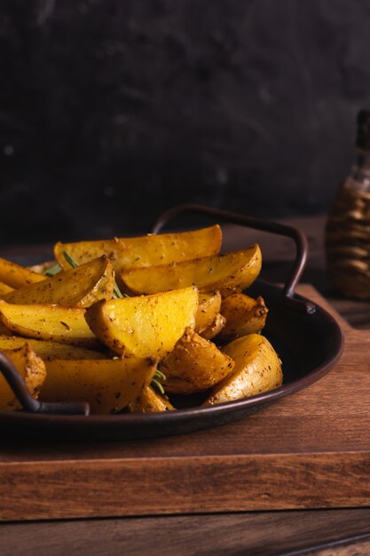 De délicieuses tranches de pommes de terre au four avec du romarin et de l'huile