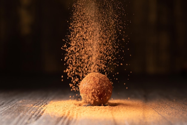 Délicieuses truffes au chocolat saupoudrées de cacao sur fond noir réfléchissant