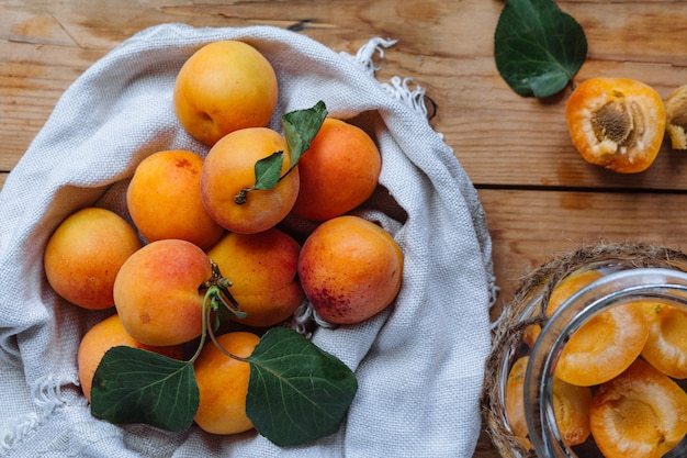 Délicieux abricots mûrs dans un bol en bois sur le gros plan de table. Vue horizontale d'en haut