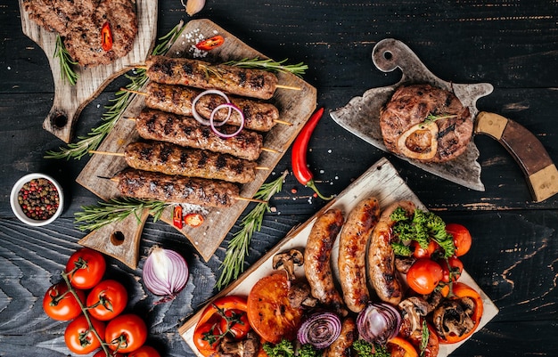 Délicieux assortiment de viandes et légumes grillés sur un barbecue avec des saucisses de porc, des brochettes de viande de boeuf hachée, du porc, du boeuf. vue de dessus.