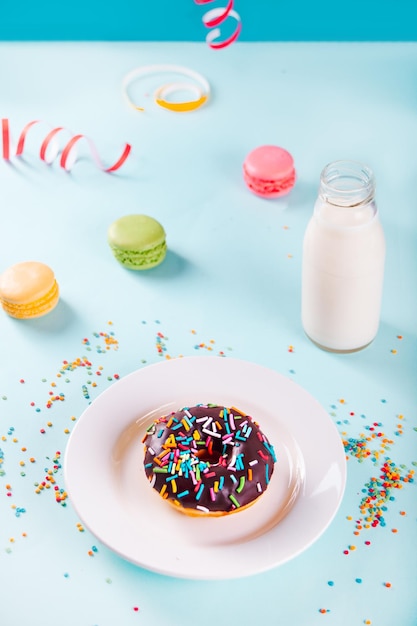 Délicieux beignet avec glaçage au chocolat avec une bouteille de lait