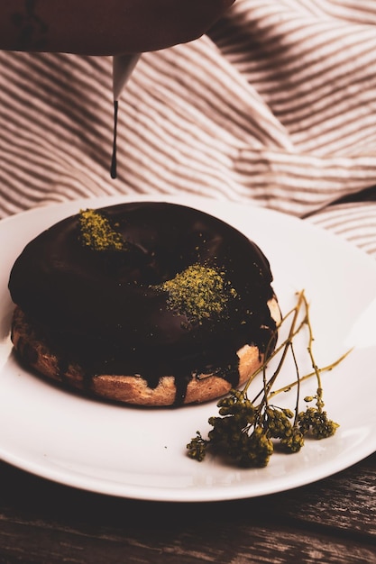 Délicieux beignet avec sauce au chocolat et morceaux de pistache