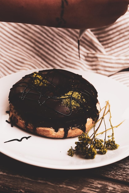 Délicieux beignet avec sauce au chocolat et morceaux de pistache