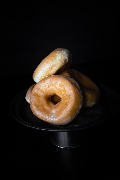 Délicieux beignets au sucre sur fond sombre