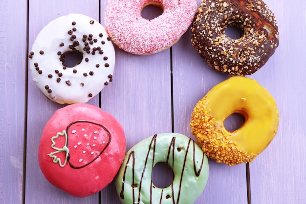 Délicieux beignets avec glaçage sur fond de bois coloré