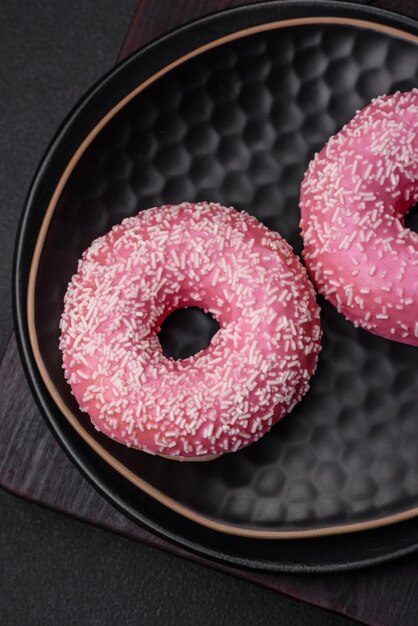 Délicieux beignets sucrés frais dans un glaçage rose fourré à la fraise