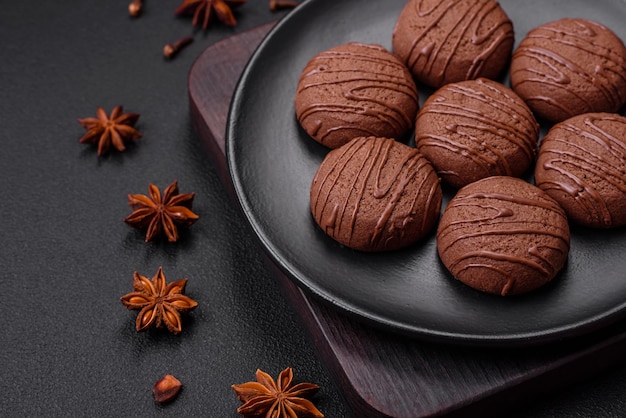 Délicieux biscuits au chocolat sucré sur une plaque en céramique noire
