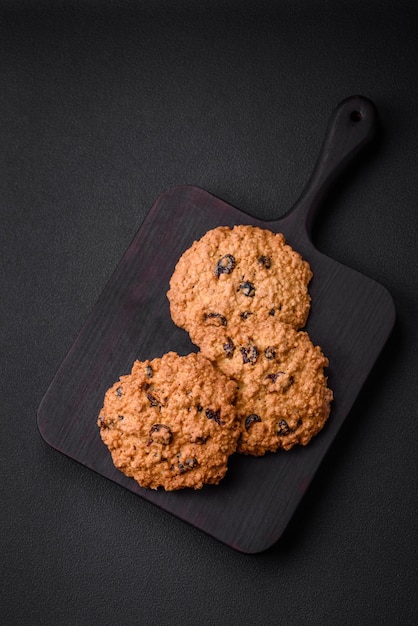 Délicieux biscuits aux raisins secs à l'avoine cuits au four sur fond de béton foncé