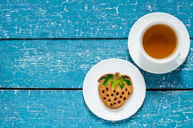 Délicieux biscuits faits maison en forme de fraises et thé en tasse