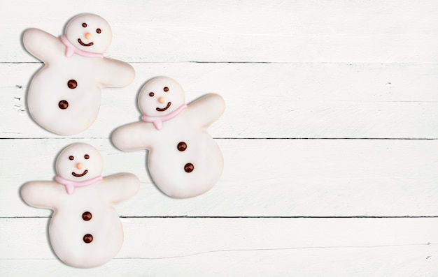 Délicieux biscuits de Noël de bonhomme de neige sur une table en bois blanc