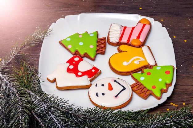 Délicieux biscuits de Noël dans une assiette près d'une branche d'arbre de Noël