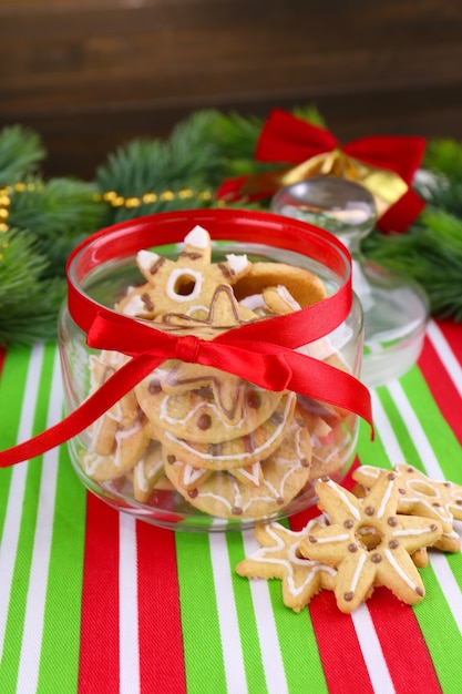 Délicieux biscuits de Noël en pot sur table sur fond de bois