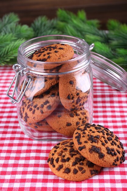 Délicieux biscuits de Noël en pot sur table sur fond de bois